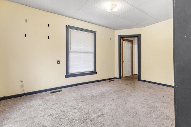 unfurnished room featuring light carpet, baseboards, visible vents, and a drop ceiling