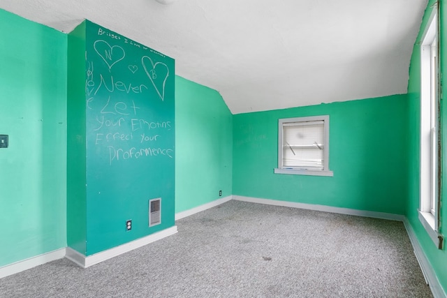 bonus room featuring lofted ceiling, carpet floors, visible vents, and baseboards