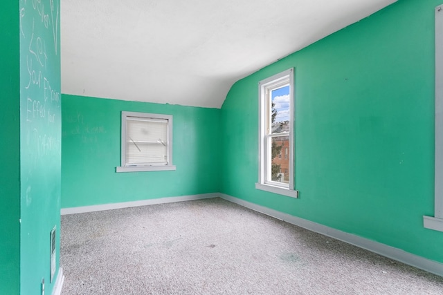 bonus room with visible vents, baseboards, lofted ceiling, a textured ceiling, and carpet flooring