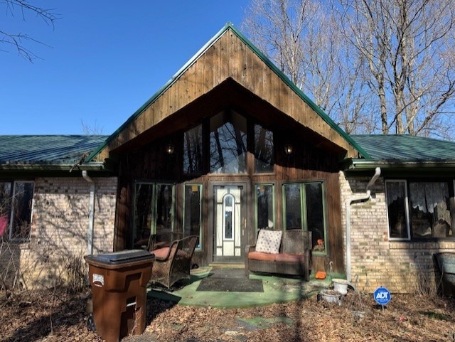 property entrance featuring brick siding and a patio area