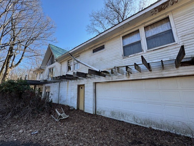 view of home's exterior featuring an attached garage and metal roof