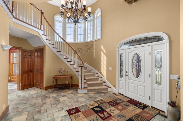 entryway with stone finish flooring, a high ceiling, plenty of natural light, and baseboards