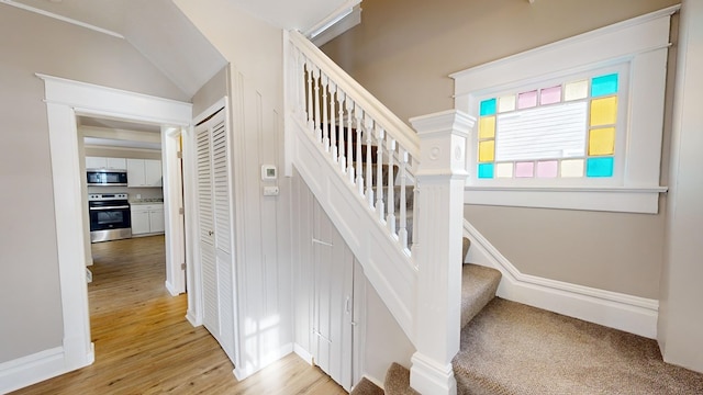 stairs with lofted ceiling and wood-type flooring