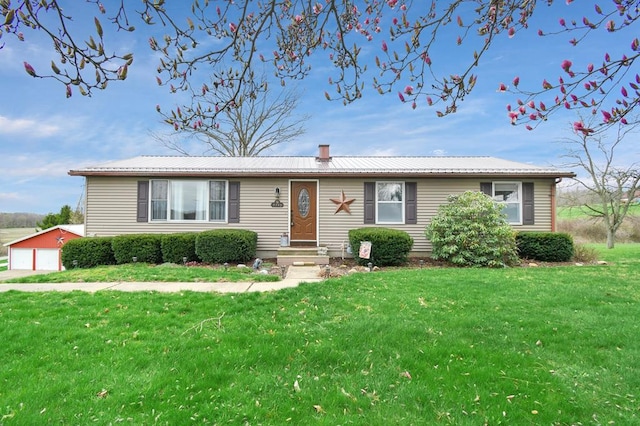 single story home featuring a front lawn, an outdoor structure, metal roof, and a garage
