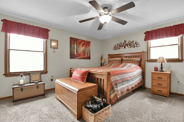 carpeted bedroom featuring baseboards and a ceiling fan