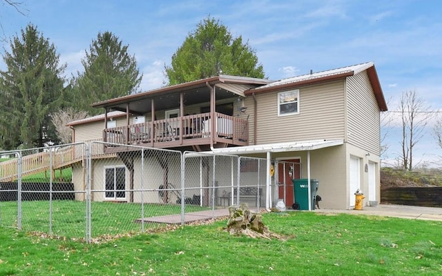 rear view of house featuring a garage, fence, and a lawn