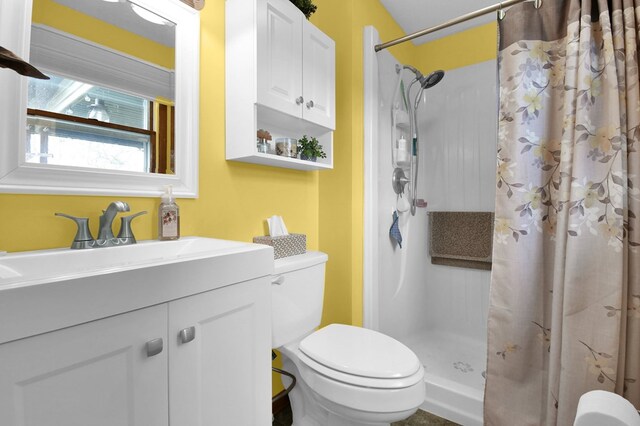 bathroom with toilet, a stall shower, and vanity