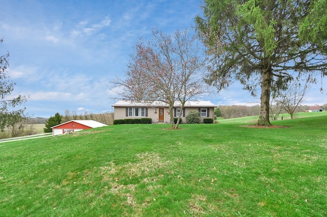 view of front of house featuring a front yard and an outbuilding