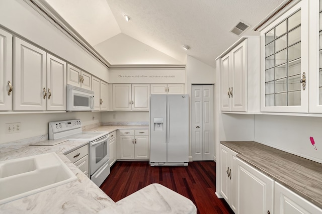 kitchen with white cabinets, a sink, visible vents, white appliances, and vaulted ceiling