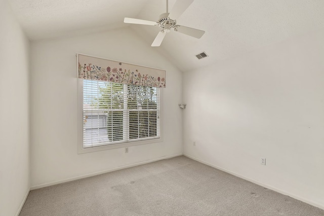 carpeted spare room with visible vents, a ceiling fan, baseboards, and vaulted ceiling