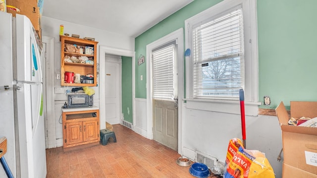 kitchen featuring visible vents, open shelves, light wood-type flooring, and freestanding refrigerator