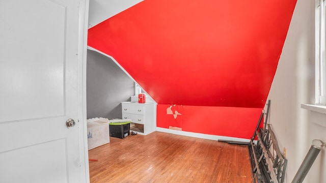 additional living space featuring wood-type flooring and vaulted ceiling