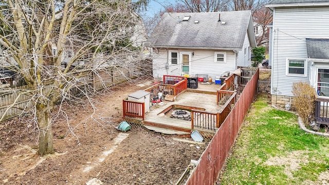 rear view of property featuring a wooden deck and fence