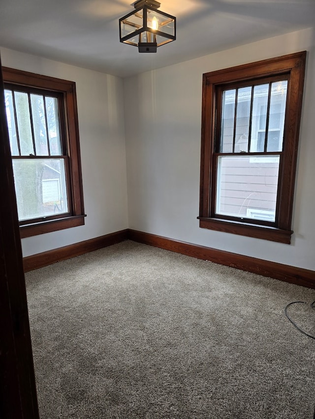 carpeted empty room with baseboards