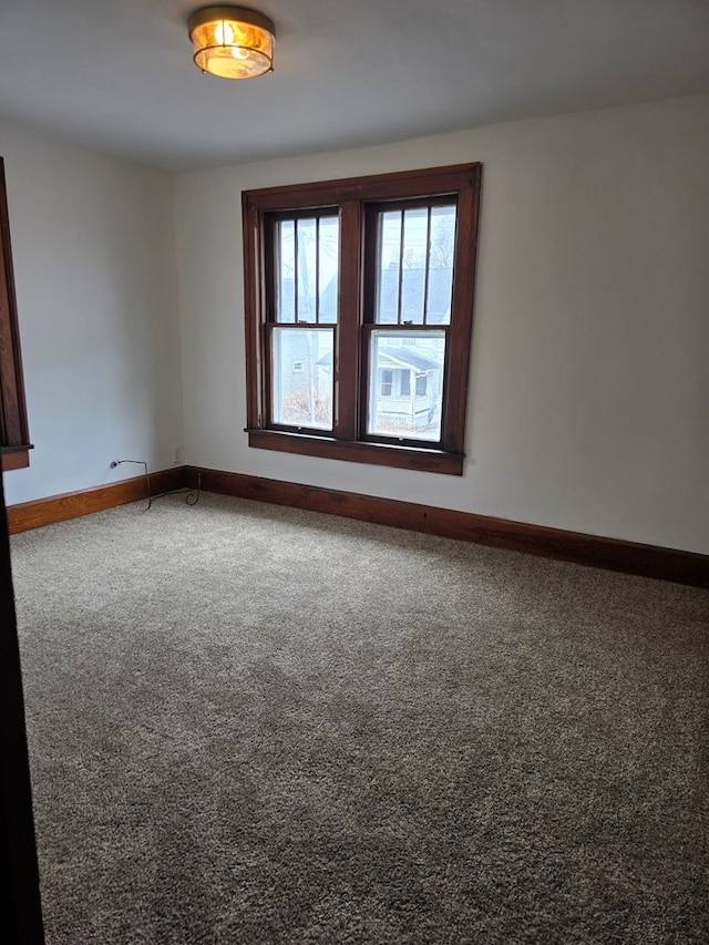 unfurnished room featuring baseboards and carpet flooring