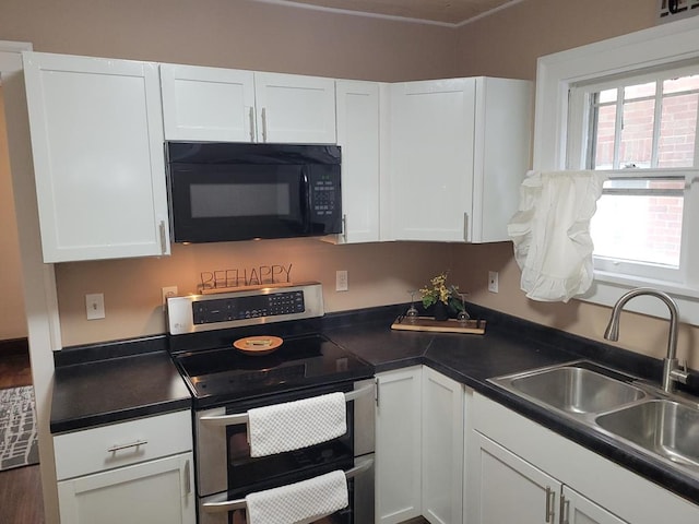 kitchen with black microwave, a sink, white cabinets, double oven range, and dark countertops
