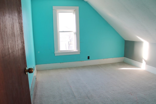 bonus room featuring a textured ceiling, a baseboard radiator, light colored carpet, and vaulted ceiling