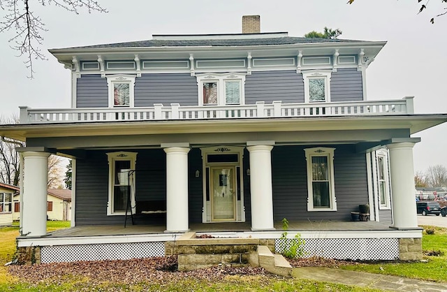 italianate house featuring covered porch and a balcony