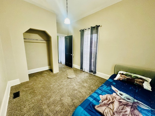 carpeted bedroom with a closet and lofted ceiling