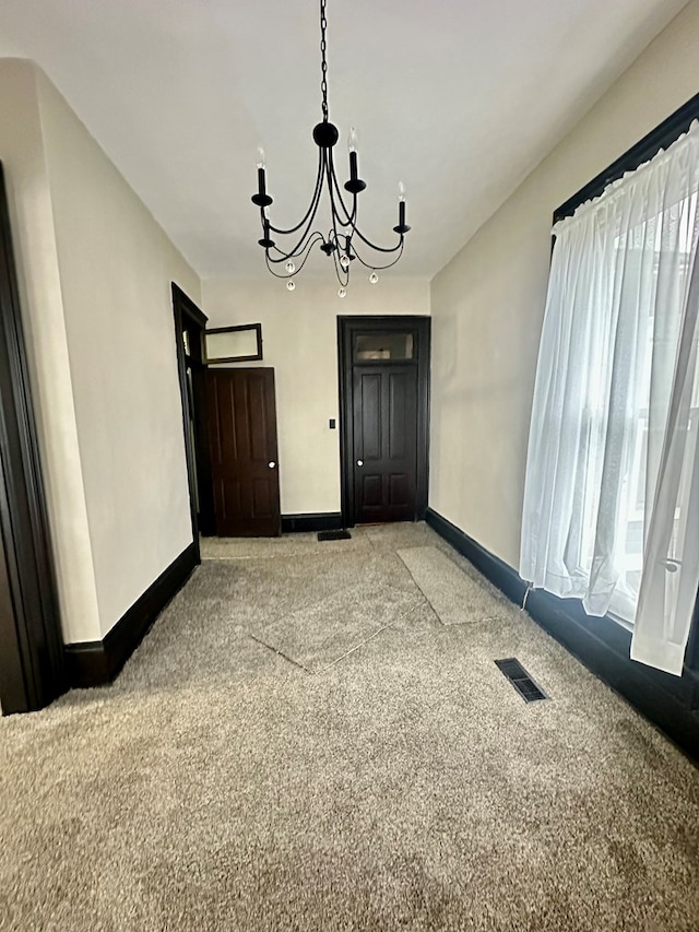 unfurnished dining area featuring light colored carpet and an inviting chandelier