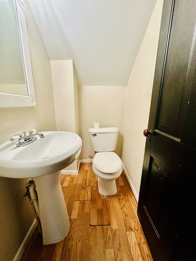 bathroom featuring vaulted ceiling, hardwood / wood-style flooring, and toilet