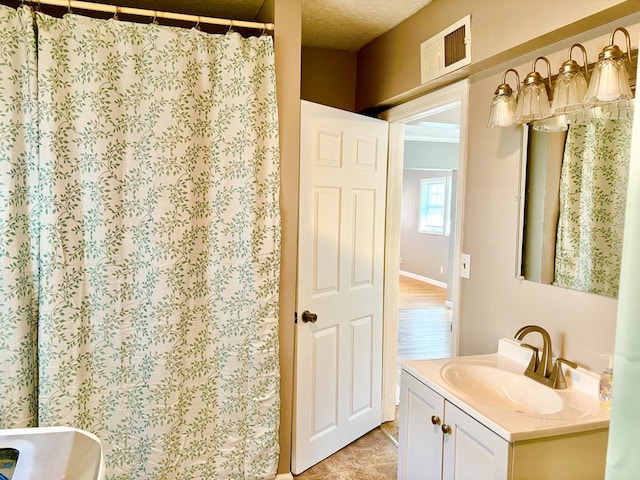 bathroom with vanity, a shower with curtain, visible vents, and a textured ceiling