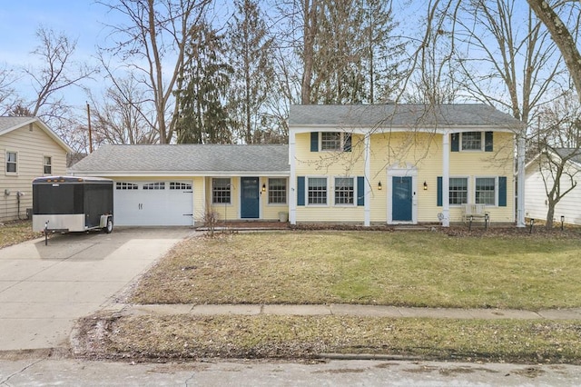 colonial home with a garage and a front yard