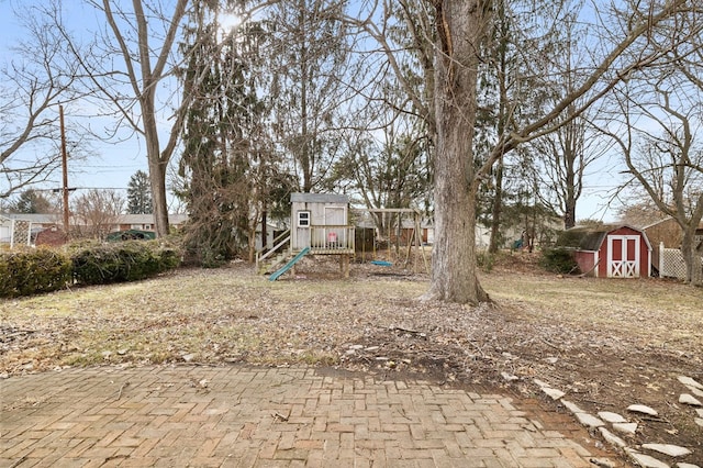 view of yard with a playground and a shed