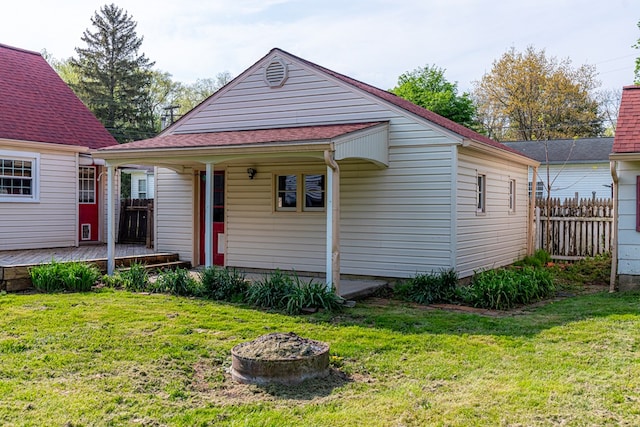 view of front of property with a deck, fence, and a front yard