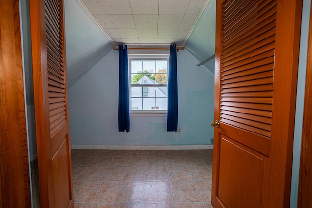 additional living space with baseboards and vaulted ceiling