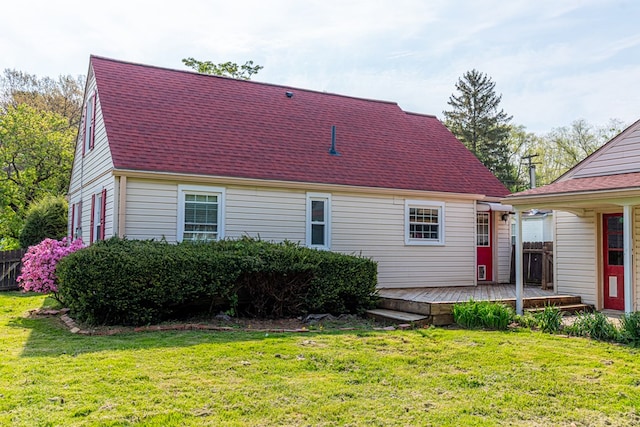back of property featuring fence, a shingled roof, a yard, and a deck