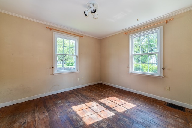 unfurnished room with visible vents, ornamental molding, a wealth of natural light, and hardwood / wood-style flooring
