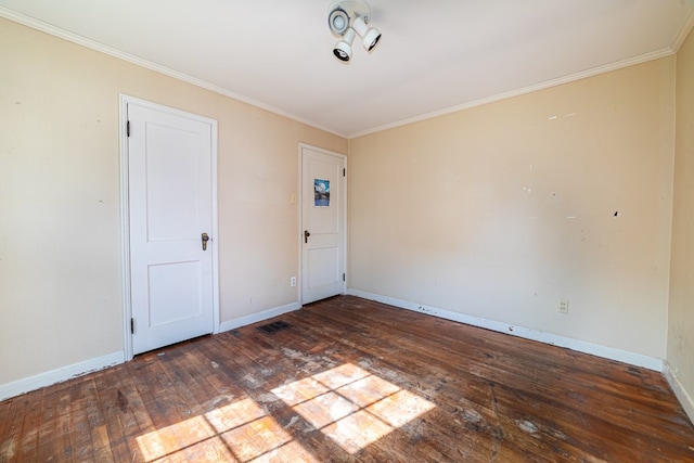 empty room with baseboards, ornamental molding, and hardwood / wood-style flooring
