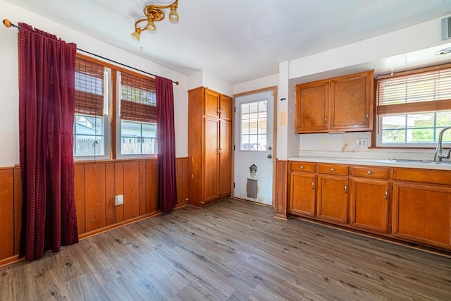 kitchen featuring brown cabinetry, a sink, and wood finished floors