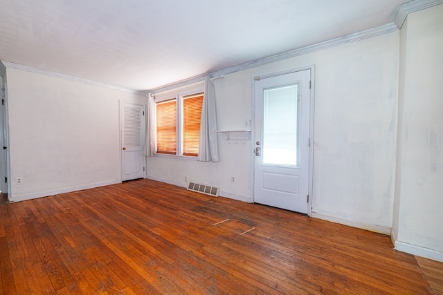 spare room featuring baseboards, visible vents, ornamental molding, and hardwood / wood-style floors