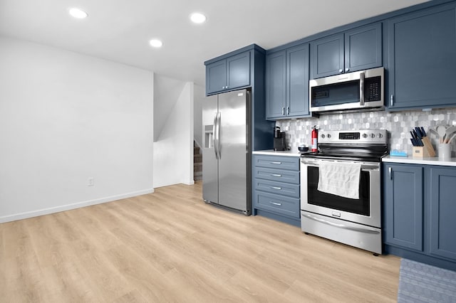 kitchen featuring stainless steel appliances, tasteful backsplash, blue cabinets, and light hardwood / wood-style flooring