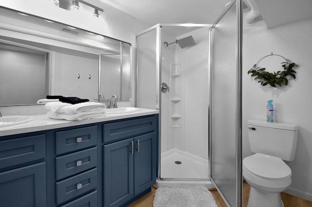 bathroom featuring vanity, a shower with shower door, hardwood / wood-style floors, and toilet