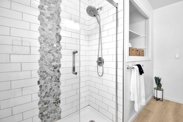 bathroom featuring hardwood / wood-style floors and tiled shower