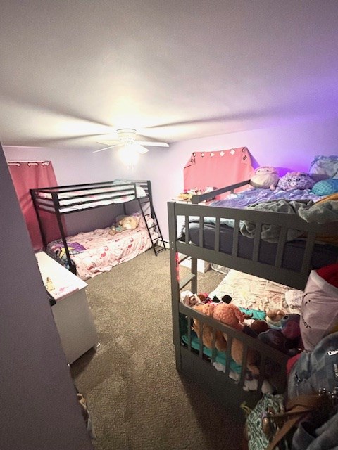 bedroom with a ceiling fan and carpet