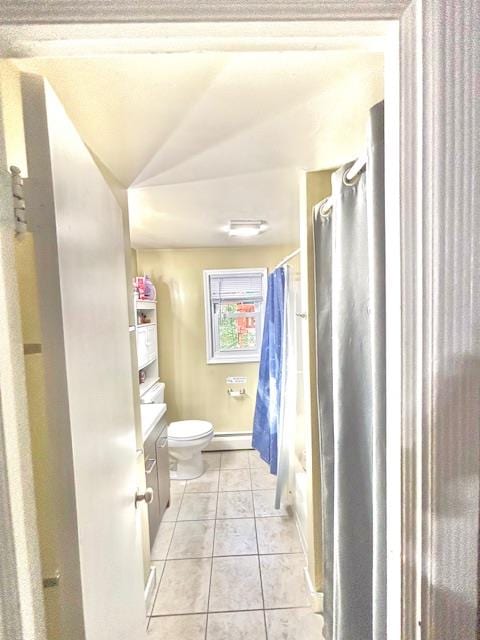 bathroom with a baseboard heating unit, toilet, vanity, and tile patterned floors