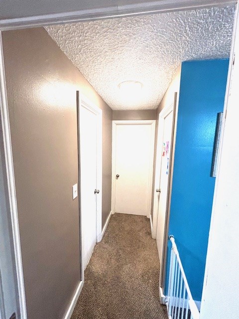 hallway with baseboards and carpet floors