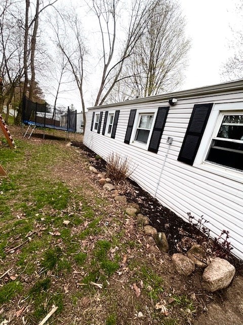 view of side of home with a trampoline