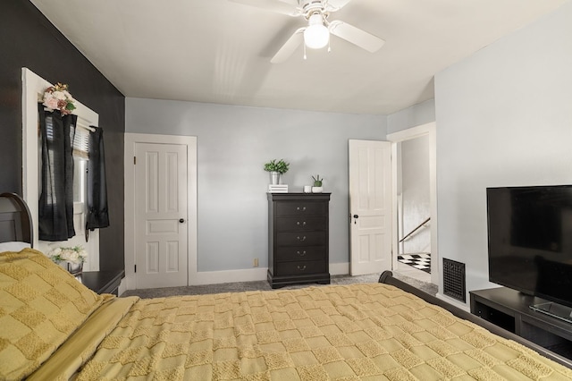 carpeted bedroom with visible vents, a ceiling fan, and baseboards