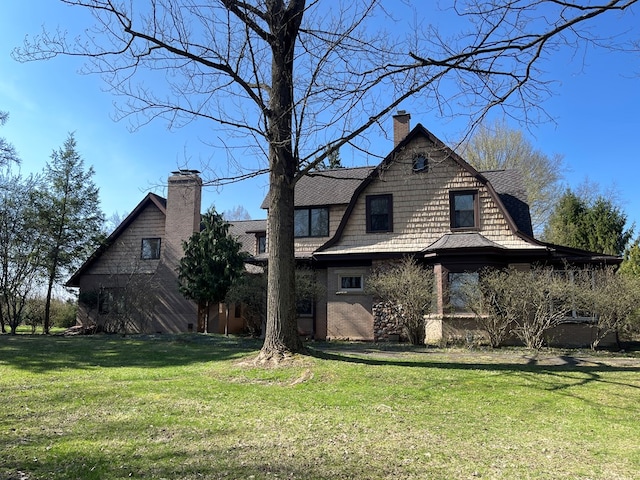 rear view of house with a chimney and a yard