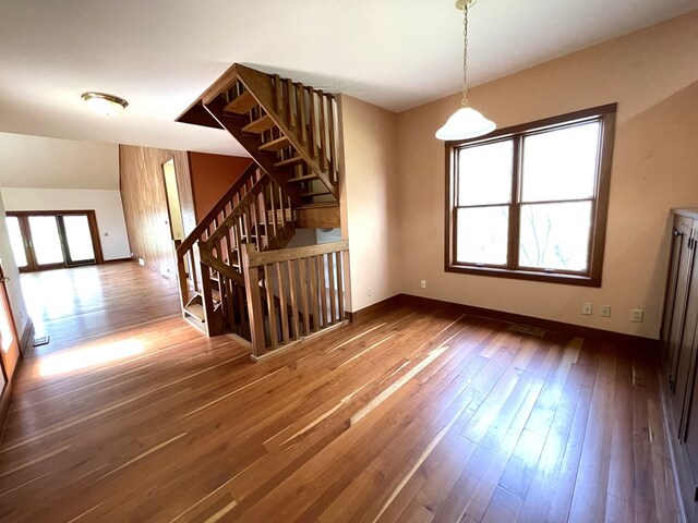 interior space with wood-type flooring, stairs, and baseboards
