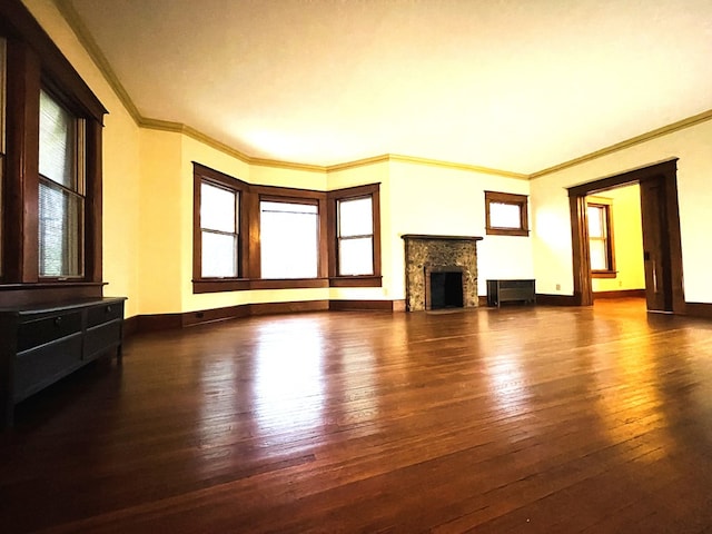 unfurnished living room featuring ornamental molding, hardwood / wood-style floors, baseboards, and a fireplace