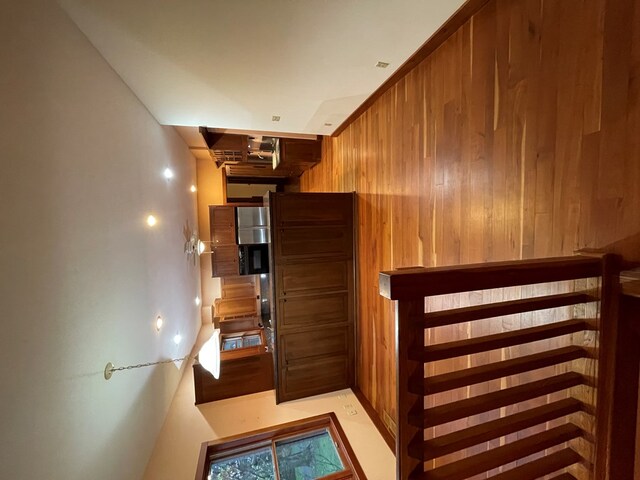hallway featuring wood walls