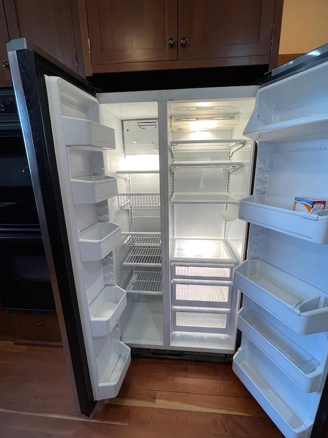 room details with refrigerator and wood finished floors