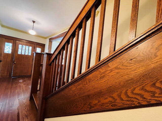 stairs with crown molding and hardwood / wood-style flooring