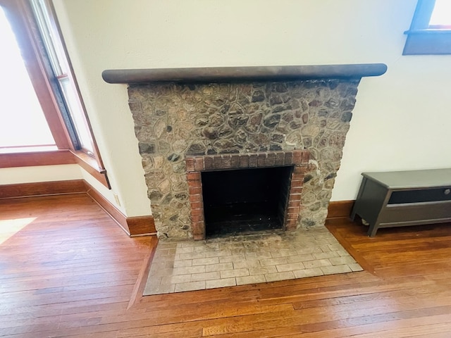 details featuring a fireplace, wood finished floors, and baseboards